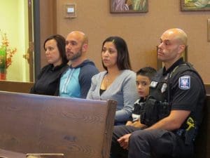 Anne Spaulding, left to right, Officer Joe Spaulding, Tina Ortiz, Rob Ortiz Jr., and Officer Rob Ortiz, listen to Xaverian Fr. Alejandro Rodriguez’s homily during the Friday, May 20 Blue Mass celebrated for public safety officials at St. Richard Parish, Racine. (Submitted photo courtesy Eloy Contreras)